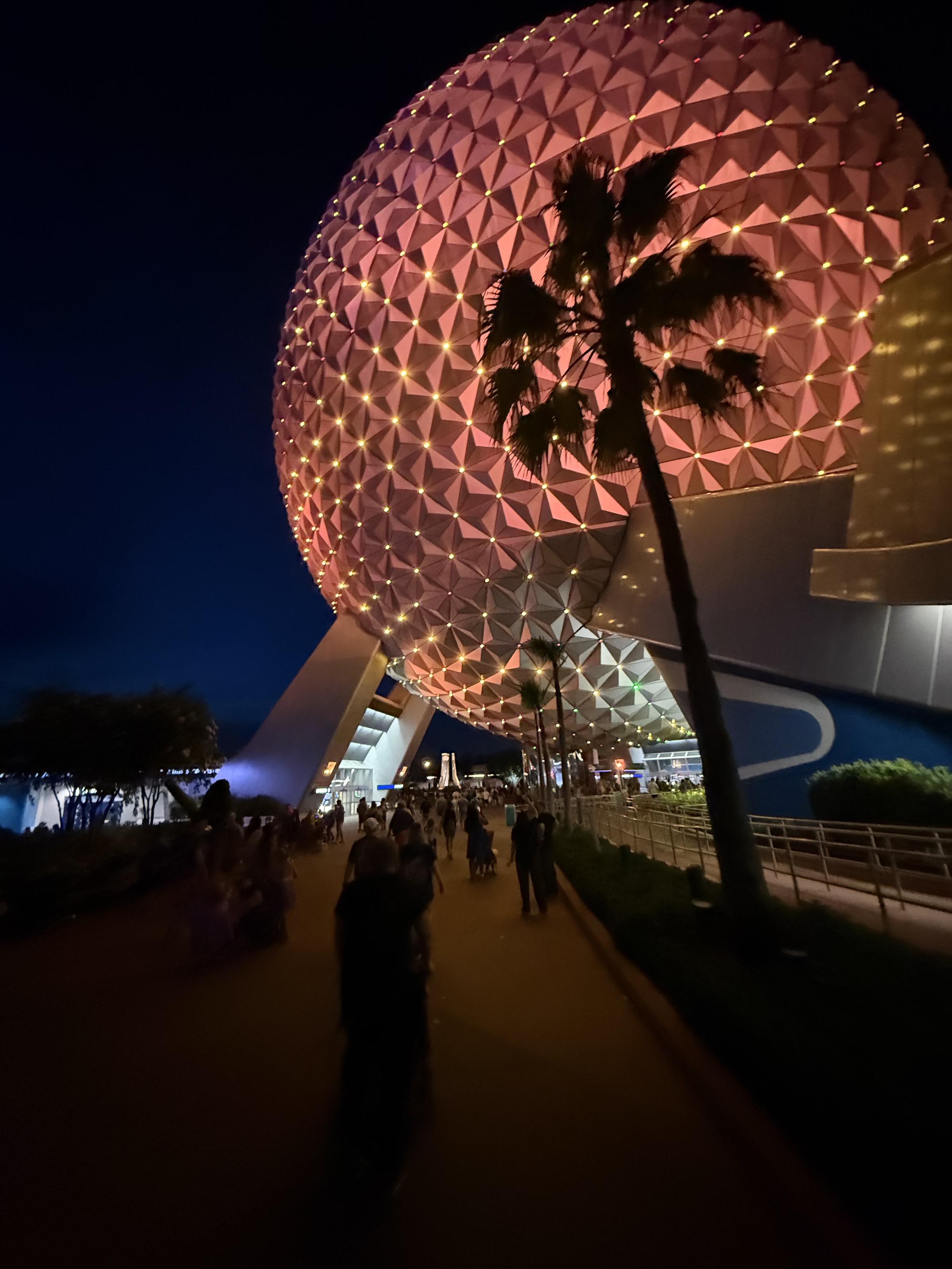 Spaceship Earth at night with guests on the walkway